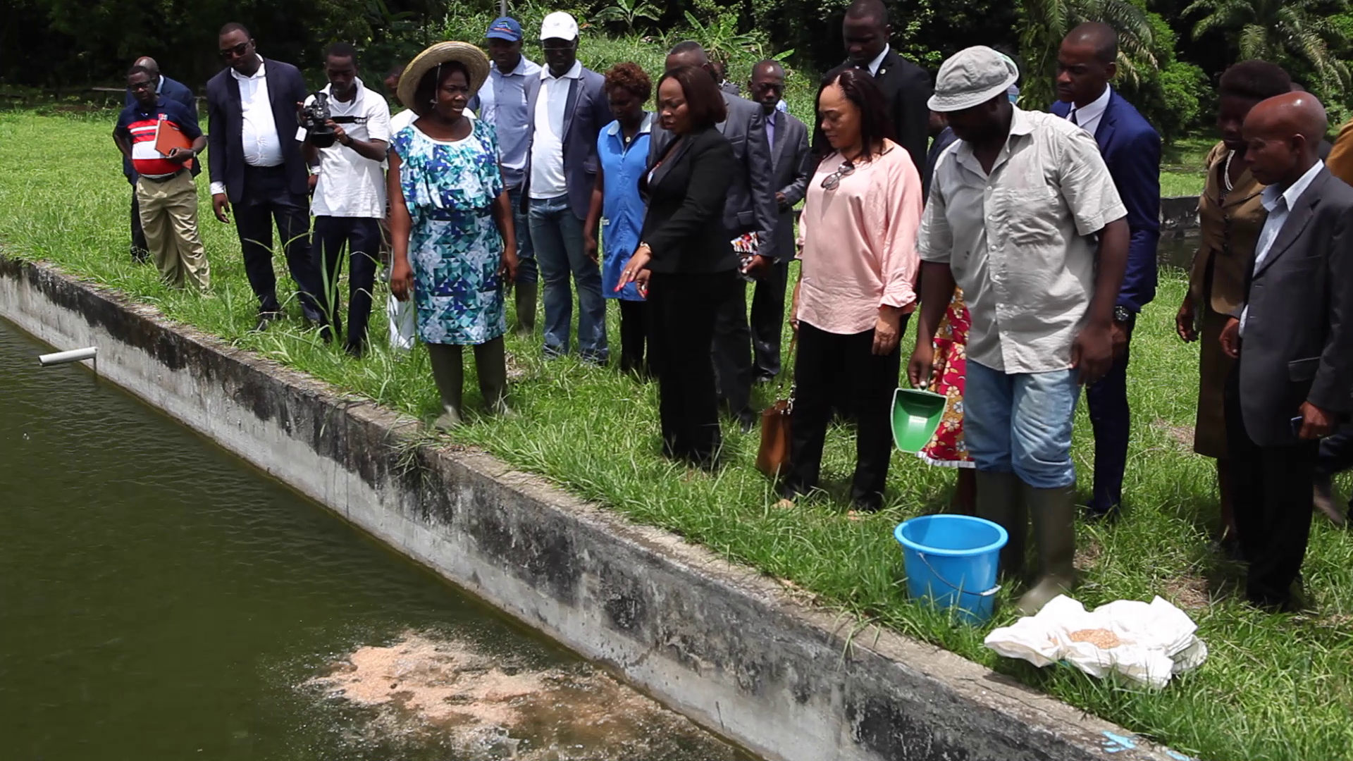 La Ministre de la Pêche et de la Mer, Prisca Koho Nlend, et sa délégation devant un étang de poisson.